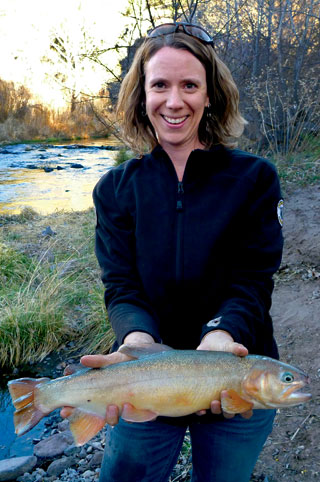 Jill Wick, Gila trout biologist for the New Mexico Department of Game and Fish, holds a large Gila trout at the East Fork of the Gila River. Photo by Eliza Gilbert, New Mexico Wildlife magazine Spring 2017 Vol60, Num1, New Mexico Department of Game and Fish.